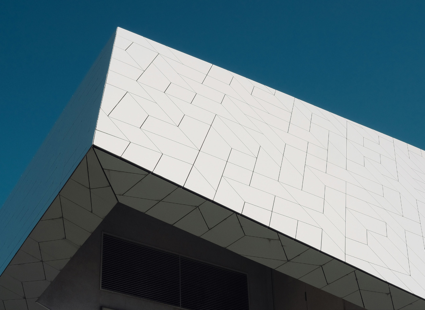 Geometric facade against a blue sky